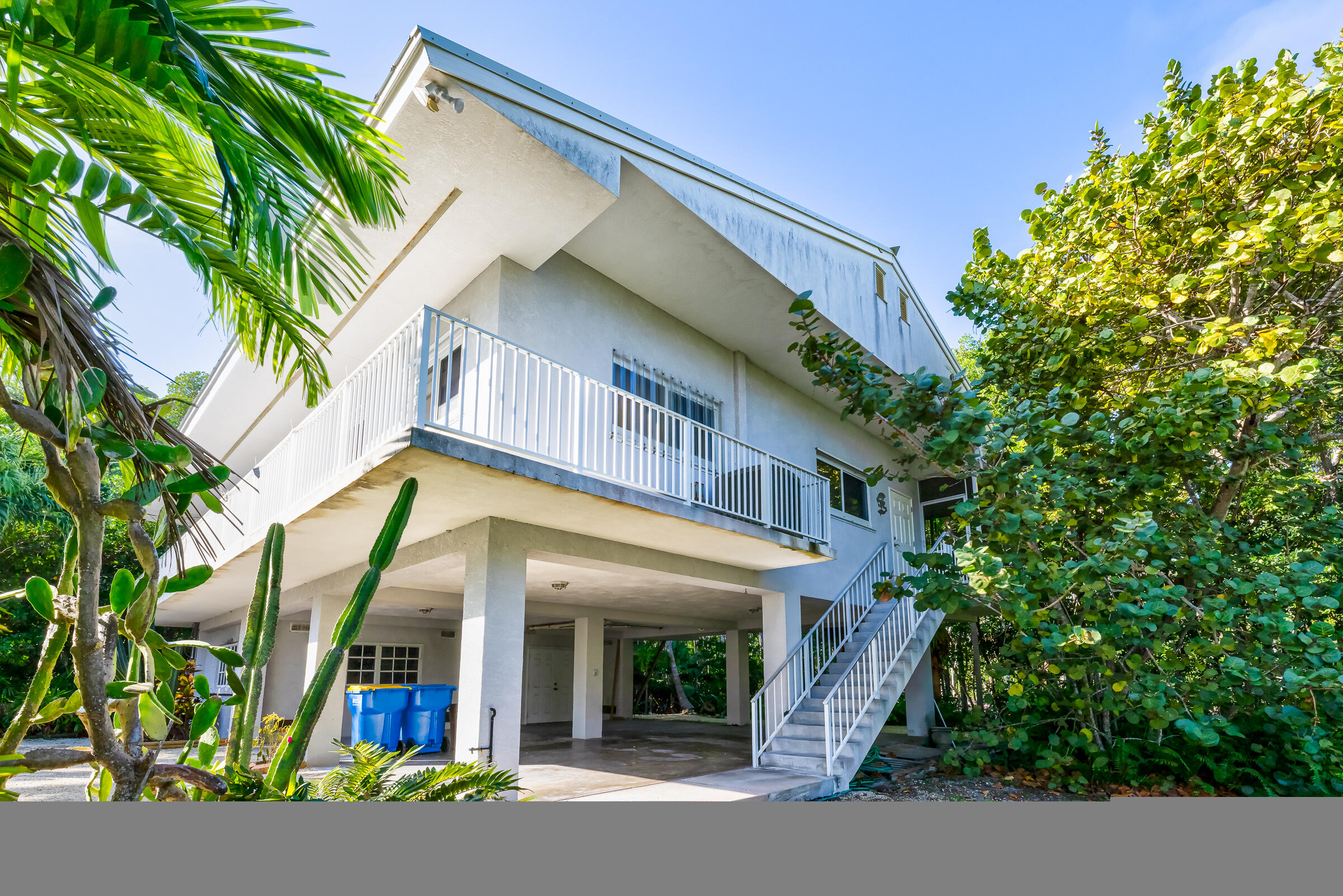 132 Galleon Road Islamorada, FL 33036 - Photo 3 of 38 a view of a white house with a large window and flower plants