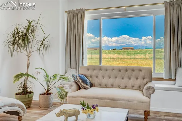 a living room with a bed furniture and a large window