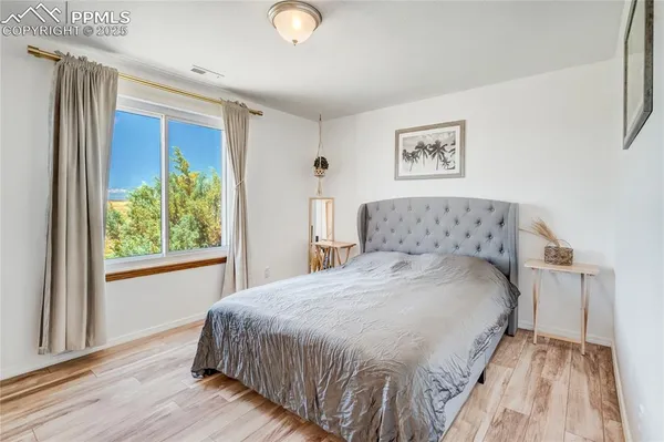 a view of an empty room with a window and kitchen view