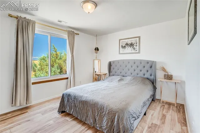 a view of an empty room with a window and kitchen view