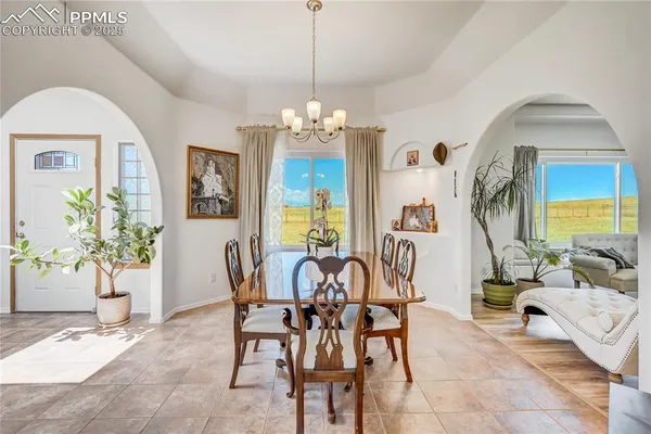 a living room with furniture a flat screen tv and floor to ceiling window