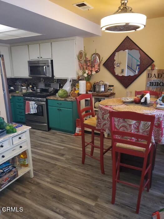 3077 Kelp Lane, Unit 108 Oxnard, CA 93035 - Photo 5 of 15 a kitchen with a wooden floor and breakfast area