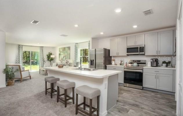 3392 East Odier Street Inverness, FL 34453 - Photo 4 of 24 a kitchen with microwave a stove and chairs