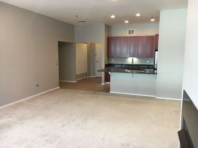 a kitchen with stainless steel appliances granite countertop a refrigerator a stove and a sink