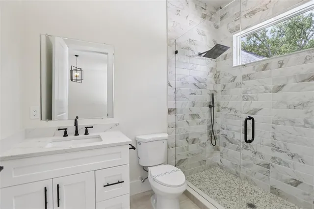 a kitchen with stainless steel appliances granite countertop a sink a stove and a refrigerator