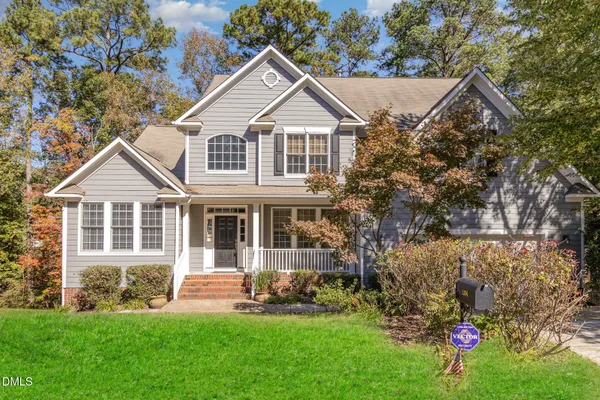 a front view of a house with a yard and green space