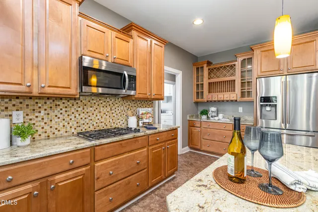 a kitchen with stainless steel appliances granite countertop a stove refrigerator and microwave