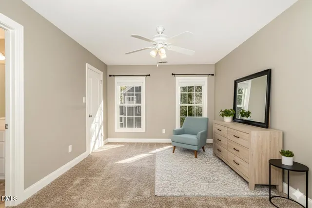 a view of an empty room with wooden floor and a ceiling fan