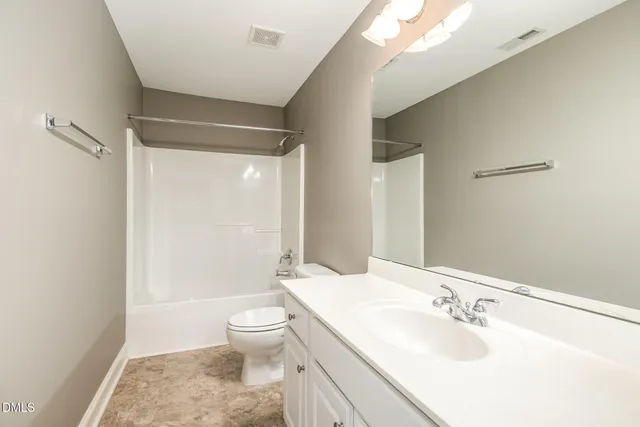 a bathroom with a sink mirror shower and toilet