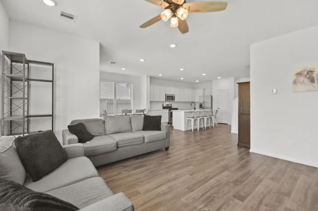 a living room with furniture and a view of kitchen