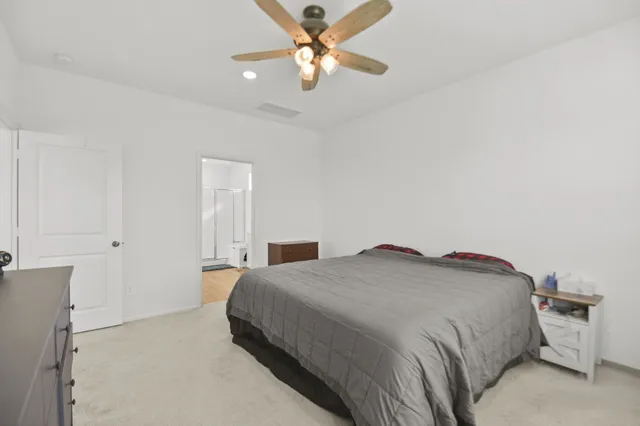 a bedroom with a bed and a ceiling fan