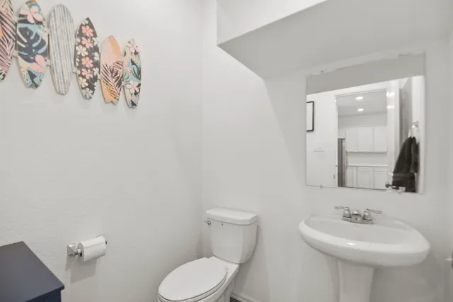 a bathroom with a toilet sink and mirror