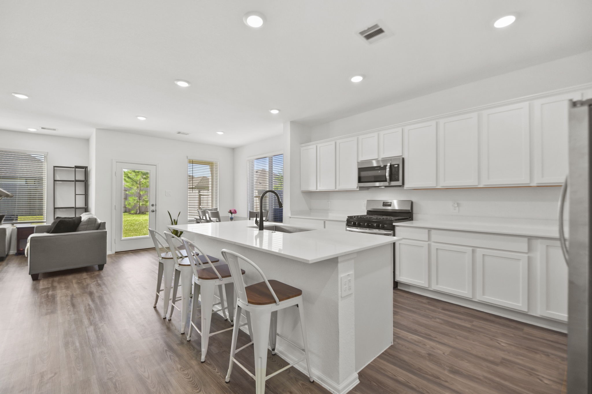 2851 Paradise Ridge Way Conroe, TX 77301 - Photo 5 of 33 a kitchen with stainless steel appliances granite countertop a stove top oven a sink dishwasher a dining table and chairs with wooden floor