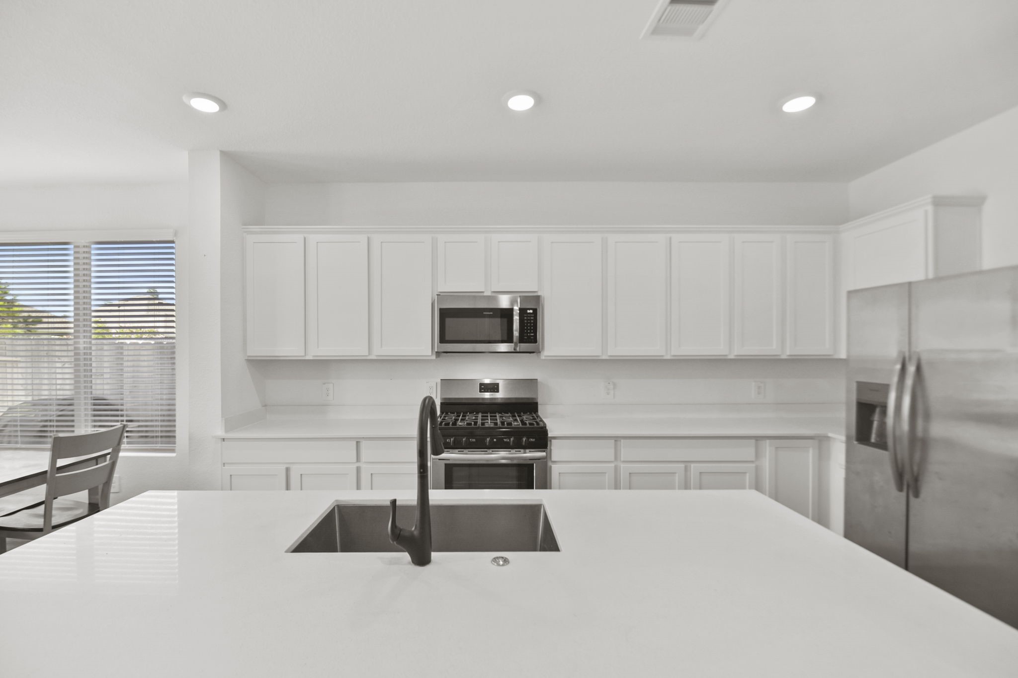 2851 Paradise Ridge Way Conroe, TX 77301 - Photo 7 of 33 a kitchen with granite countertop a refrigerator sink and cabinets