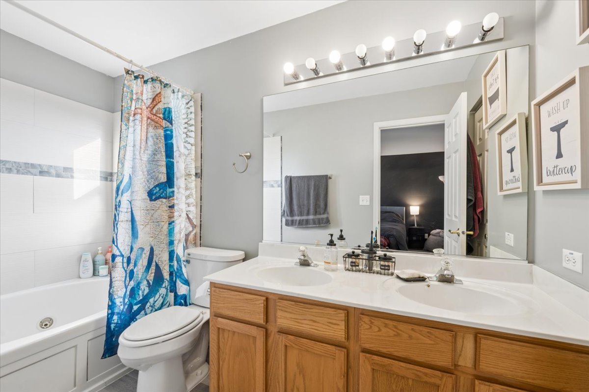 821 Red Barn Lane Elgin, IL 60124 - Photo 12 of 27 a bathroom with a sink a toilet a mirror a vanity and shower
