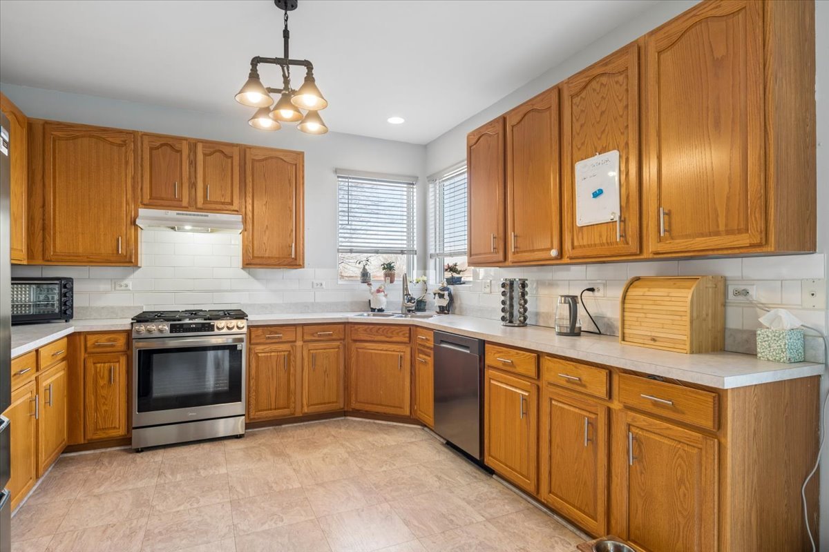 821 Red Barn Lane Elgin, IL 60124 - Photo 5 of 27 a kitchen with granite countertop stainless steel appliances a stove sink and cabinets