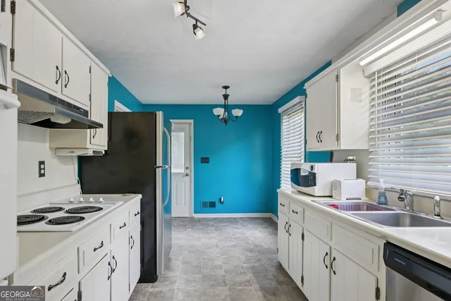 a kitchen with stainless steel appliances a sink stove and refrigerator