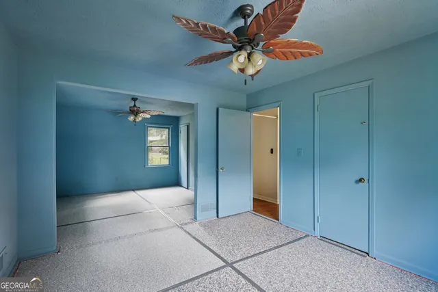 a bedroom with a bed and a chandelier fan