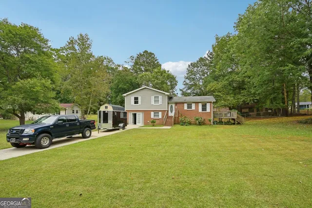 a view of a big house with a big yard and large trees