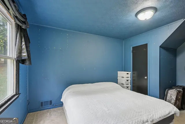 a bedroom with a bed and a window