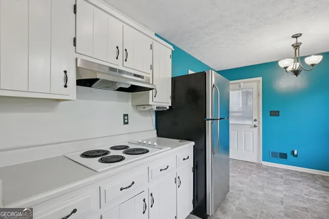 a kitchen with stainless steel appliances a stove a refrigerator and cabinets
