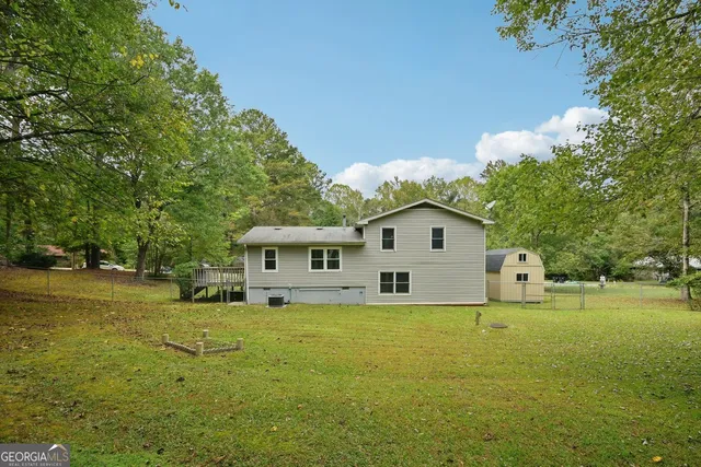 a view of a house with a big yard and large trees