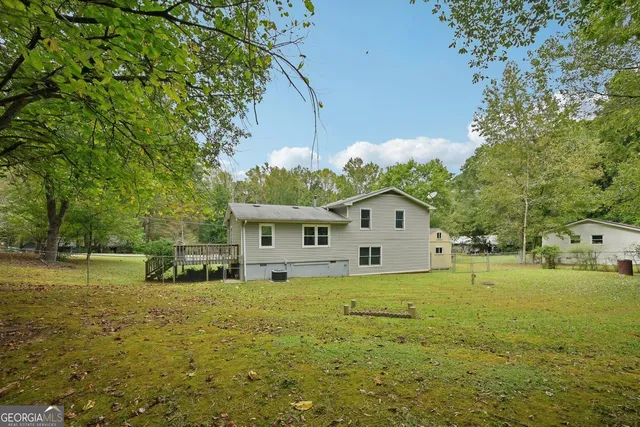 a view of a house with a big yard and large trees