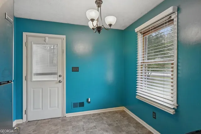a view of a room that has a large window and wooden floor