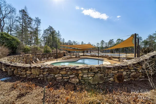 a view of a park with large trees and a wooden fence