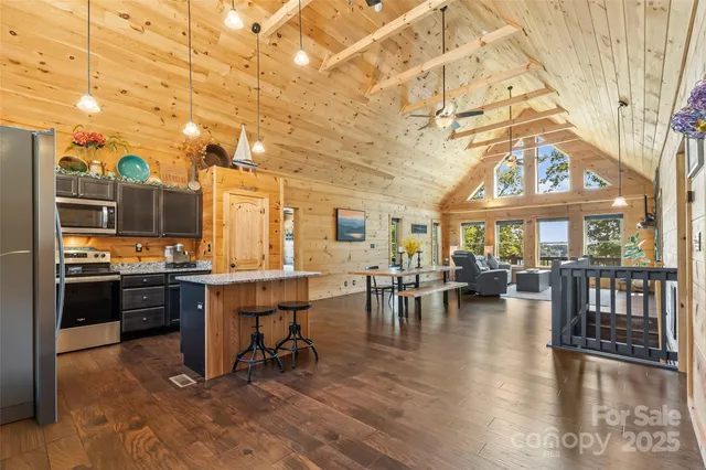 a kitchen with stainless steel appliances granite countertop a refrigerator a stove and a wooden floors