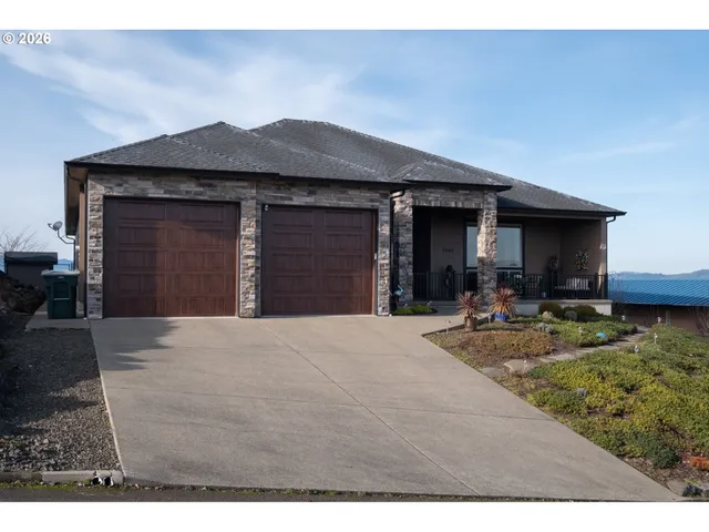 a view of a house with small yard plants and wooden fence