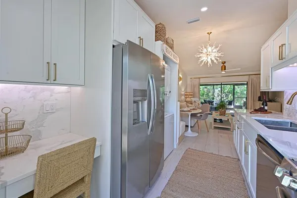 a kitchen with granite countertop a refrigerator a sink a stove and dining table