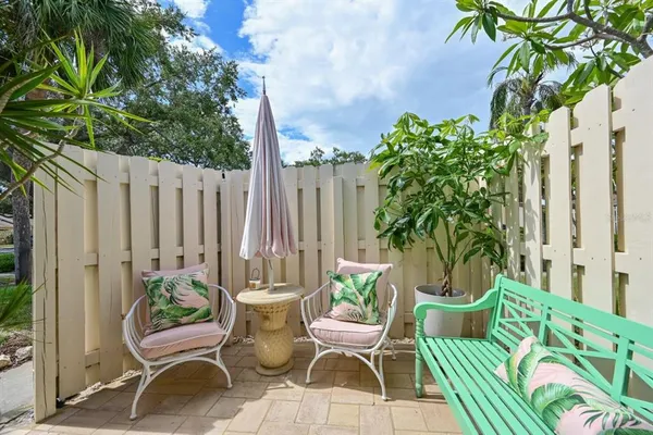 a view of two chairs in patio with potted plants