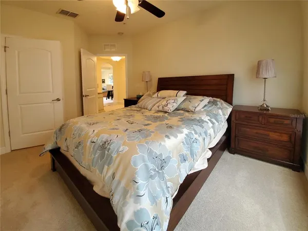 a spacious bedroom with a bed and a chandelier