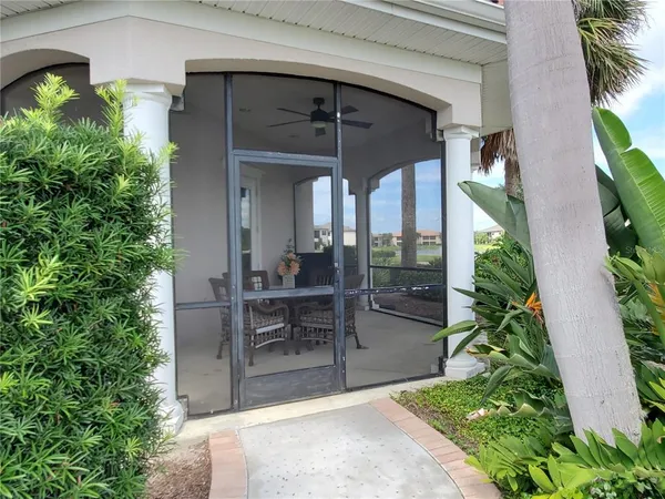 a view of a porch with chairs and potted plants