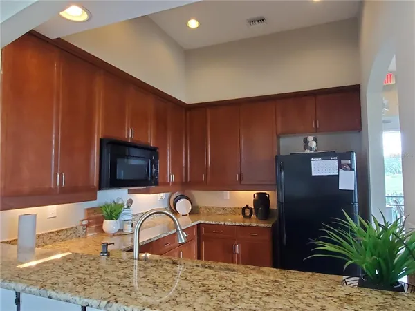 a kitchen with a refrigerator sink and wooden cabinets
