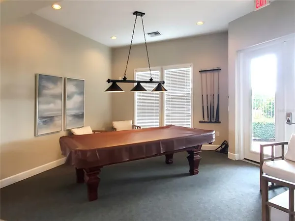 a room with pool table and windows
