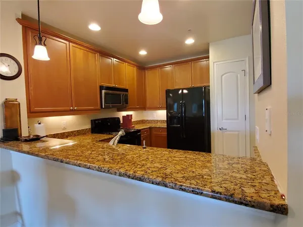 a kitchen with stainless steel appliances granite countertop a refrigerator stove top oven and sink