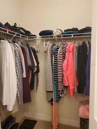 a view of walk in closet with clothes and shoes