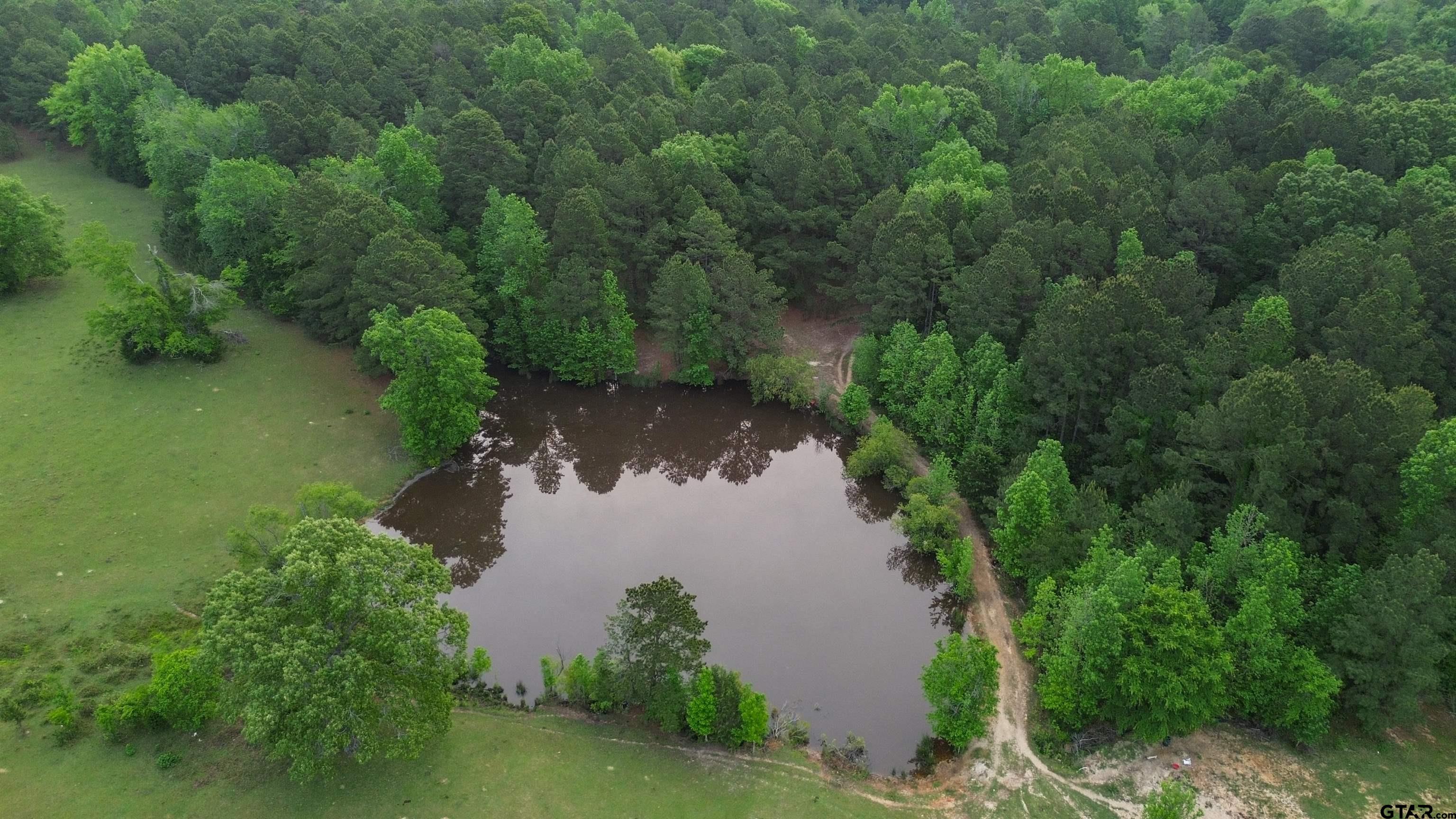 an aerial view of a house with a yard and lake view