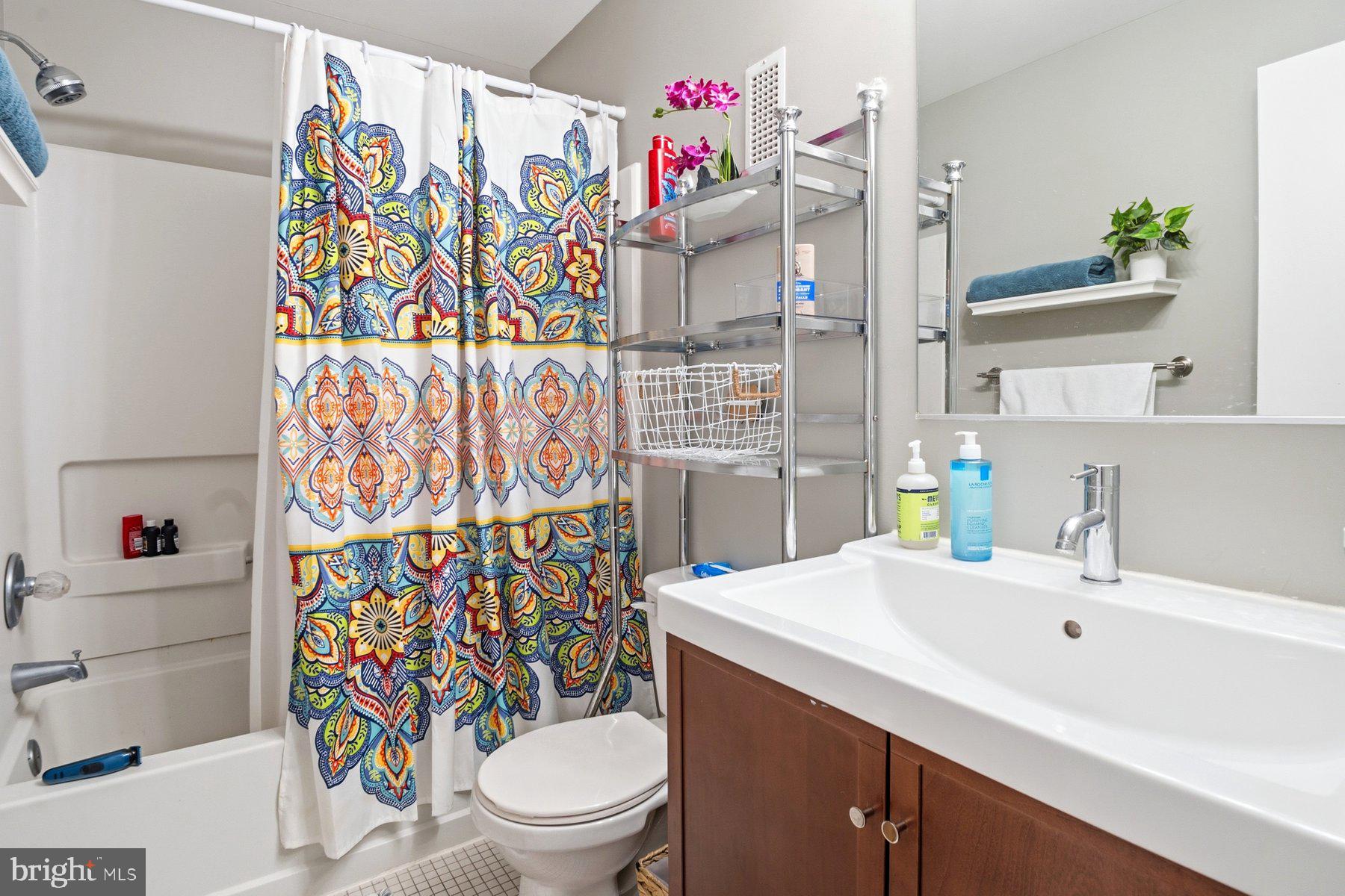 642 South Charles Street, Unit R 22 Baltimore, MD 21230 - Photo 25 of 26 a bathroom with a sink a toilet and shower curtain