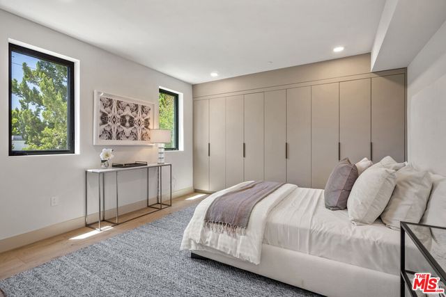 a spacious bedroom with a bed and a lamp