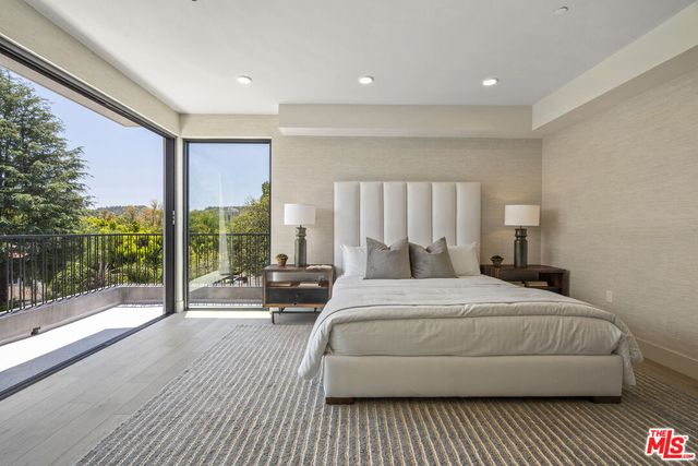 a large bedroom with a bed and a large window