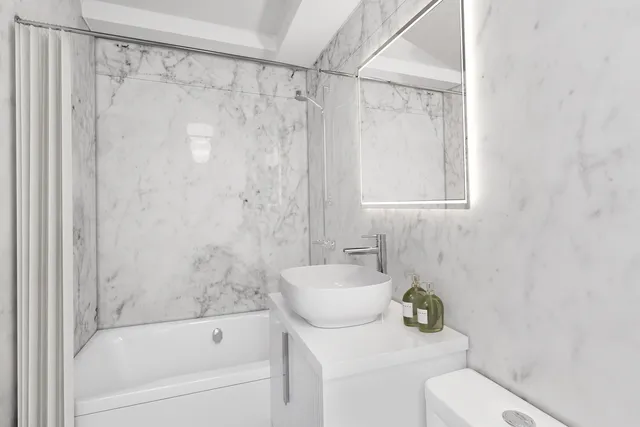 a view of kitchen and empty room with cabinet