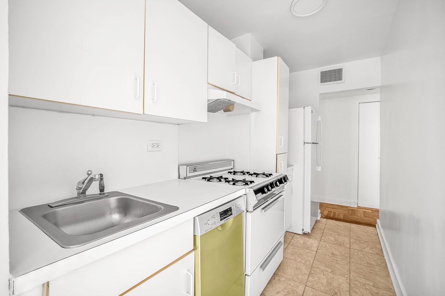 233 East 70th Street, Unit 10T Manhattan, NY 10021 - Photo 9 of 14 a kitchen with stainless steel appliances granite countertop a sink stove and refrigerator