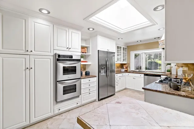 a kitchen with stainless steel appliances a refrigerator sink and microwave
