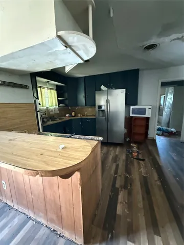 a view of kitchen with refrigerator microwave and wooden floor