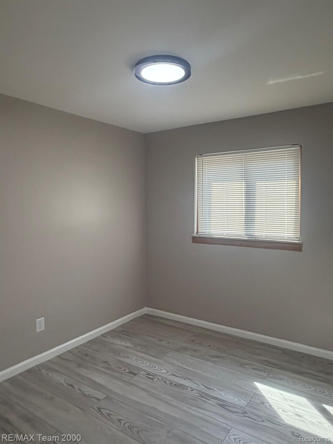 9023 Evergreen Road Detroit, MI 48228 - Photo 14 of 21 Neutral wall finishes, wood-finish flooring, flush mount ceiling light, and window with blinds