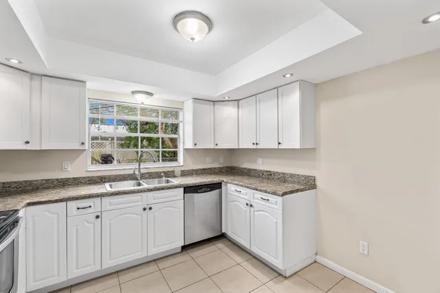 a kitchen with a sink dishwasher a stove and cabinets