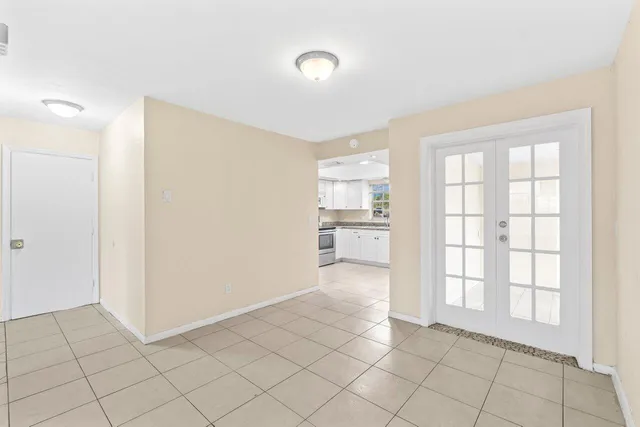 a view of an empty room with window and cabinet